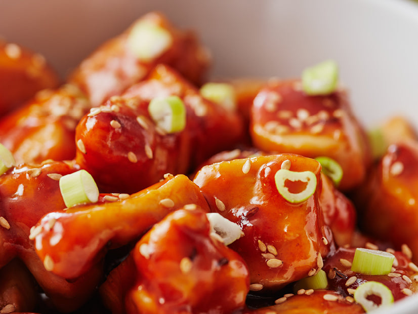 Sweet and sour chipotle-glazed chicken with sesame seeds and green onions